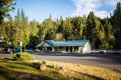 a building on the side of a road with trees at Yosemite Lakes River Yurt 21 in Harden Flat