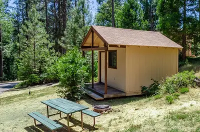 a small shed with a picnic table and a bench at Yosemite Lakes Bunkhouses in Harden Flat