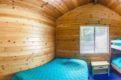a log cabin with a bed in a room at Yosemite Lakes Bunkhouses in Harden Flat