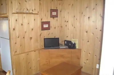 a room with a wooden wall with a computer on a desk at Yosemite Lakes Wheelchair Accessible Cabin 46 in Harden Flat