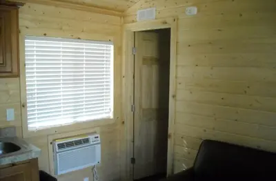 a log cabin with a window and an air conditioner at Yosemite Lakes Wheelchair Accessible Cottage 53 in Harden Flat