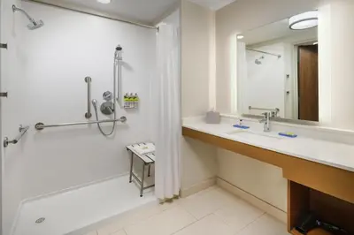 a bathroom with a tub and a sink and a shower at Holiday Inn Express & Suites Oakhurst-Yosemite Park Area by IHG in Oakhurst