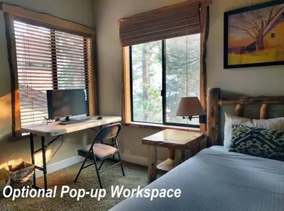 a bedroom with a bed and a desk with a computer at Village Treehouse #2 in Mammoth Lakes