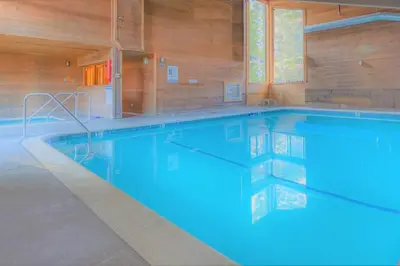 a large swimming pool with blue water in a building at Village Treehouse #2 in Mammoth Lakes