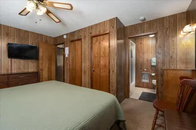 a bedroom with a bed and a flat screen tv at PaPa Bear Cabin in North Wawona