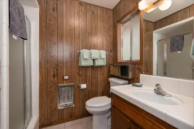 a bathroom with a toilet and a sink and a mirror at PaPa Bear Cabin in North Wawona