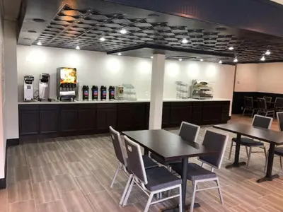 a restaurant with two tables and chairs and a counter at SureStay Plus Hotel by Best Western Sacramento Cal Expo in Sacramento