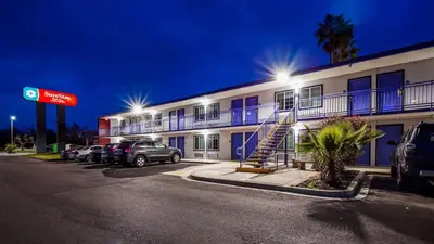 a hotel with cars parked in a parking lot at SureStay Plus Hotel by Best Western Sacramento Cal Expo in Sacramento