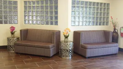 two chairs and a chair in a room with windows at SureStay Plus Hotel by Best Western Sacramento Cal Expo in Sacramento