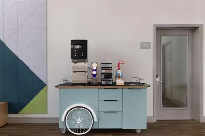 a blue cart with a coffee maker on top of it at Spark By Hilton Santa Nella in Santa Nella Village