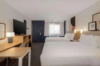 a hotel room with two beds and a flat screen tv at Spark By Hilton Santa Nella in Santa Nella Village