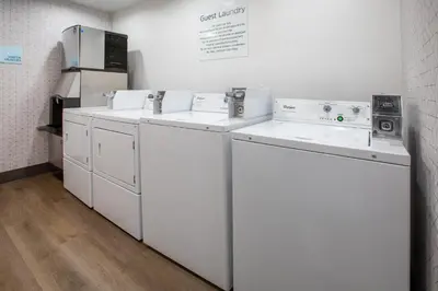 a row of washers and dryers in a room at Holiday Inn Express & Suites Lathrop by IHG in Lathrop
