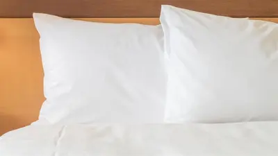 a bed with white sheets and pillows on it at Holiday Inn Express Madera by IHG in Madera