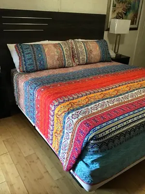 a bed with a colorful blanket on top of it at Starlight Motel in Big Pine