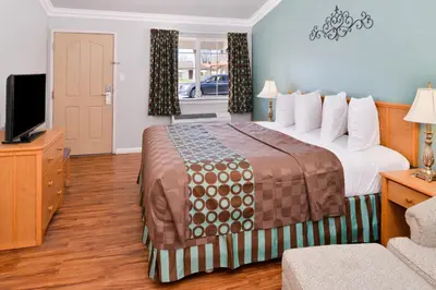 a hotel room with a bed and a flat screen tv at Americas Best Value Inn Los Banos in Los Banos