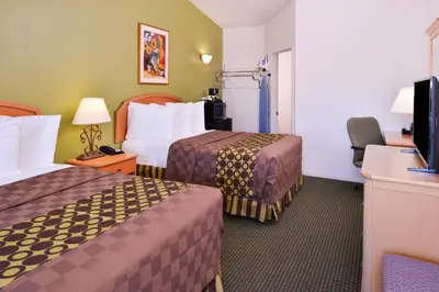 a hotel room with two beds and a flat screen tv at Americas Best Value Inn Los Banos in Los Banos