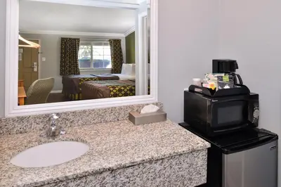a bathroom with a sink and a large mirror at Americas Best Value Inn Los Banos in Los Banos