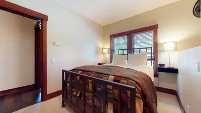 a bedroom with a bed and a large window at Juniper Crest 1 Apartment in Mammoth Lakes