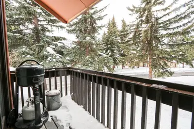 a snow covered balcony with a view of trees at Mammoth Reservations in Mammoth Lakes