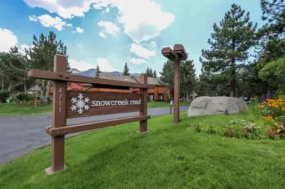 a sign in the grass next to a street at Mammoth Reservations in Mammoth Lakes