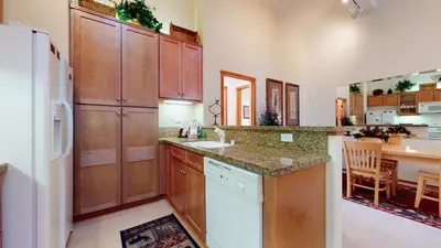 a kitchen with wooden cabinets and a white refrigerator at Snowcreek 1005 Apartment in Old Mammoth