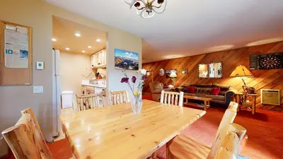 a dining room and living room with a wooden table at Snowcreek 253 Apartment in Mammoth Lakes