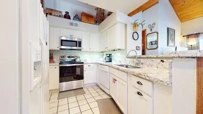 a kitchen with white cabinets and white appliances at Snowcreek 638 Apartment in Old Mammoth