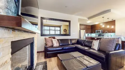 a living room with a leather couch and a fireplace at Solstice 10 Apartment in Mammoth Lakes