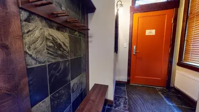a hallway with an orange door and a bench at Solstice 10 Apartment in Mammoth Lakes