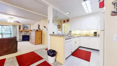 a kitchen with white cabinets and a red rug at Summit 3 Apartment in Mammoth Lakes