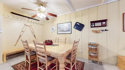 a dining room with a table and chairs and a ceiling fan at Summit 3 Apartment in Mammoth Lakes