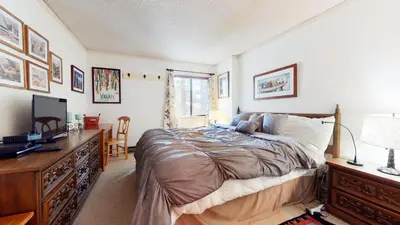 a bedroom with a bed and a desk with a television at Summit 45 Apartment in Mammoth Lakes