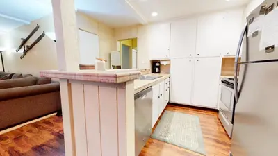 a kitchen with white cabinets and a counter top at Summit 49 Apartment in Mammoth Lakes