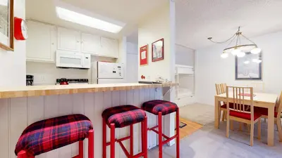 a kitchen with red stools and a dining room table at Mammoth Reservations in Mammoth Lakes