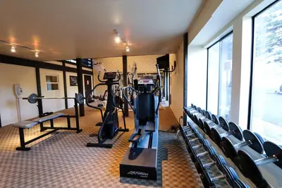 a gym with treadmills and machines in a room at Mammoth Reservations in Mammoth Lakes
