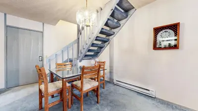 a dining room with a table and chairs and a staircase at Mammoth Reservations in Mammoth Lakes