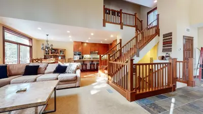 a living room with a couch and a staircase at Timbers 1 Apartment in Mammoth Lakes