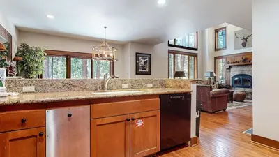 a large kitchen with a sink and a fireplace at Timbers 18 Apartment in Mammoth Lakes