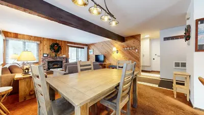 a dining room and living room with a wooden table and chairs at Wild Flower 37 Apartment in Mammoth Lakes