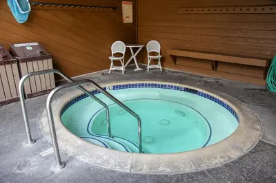 a hot tub with two chairs and a table and a bench at Wild Flower 37 Apartment in Mammoth Lakes