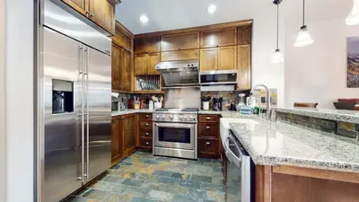 a kitchen with wooden cabinets and stainless steel appliances at Mammoth Reservations in Mammoth Lakes