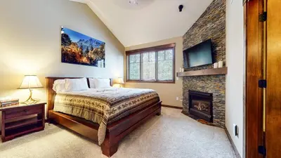 a bedroom with a bed and a fireplace at Mammoth Reservations in Mammoth Lakes