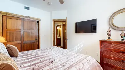 a bedroom with a bed and a tv on a wall at Mammoth Reservations in Mammoth Lakes