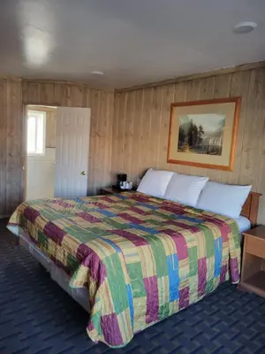 a bedroom with a large bed with a colorful blanket at Townhouse Motel in Bishop