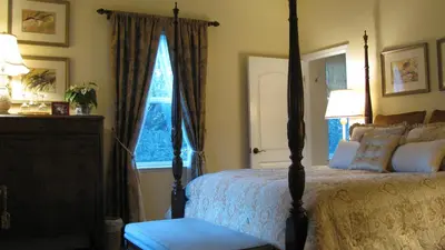 a bedroom with a bed and a dresser and a window at Yosemite Rose Bed and Breakfast in Groveland