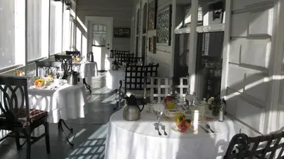 a restaurant with tables with white table cloths on them at Yosemite Rose Bed and Breakfast in Groveland