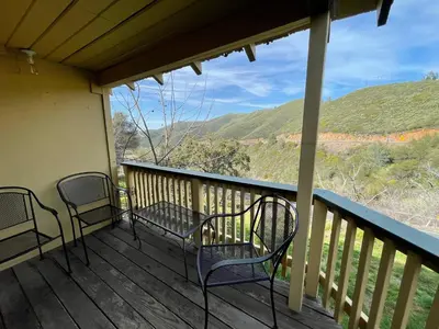 a porch with chairs and a view of the mountains at Priest Station Cafe & Cabins in Groveland
