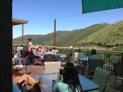 a group of people sitting at tables on a deck at Priest Station Cafe & Cabins in Groveland