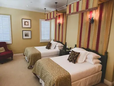 a hotel room with two beds and a chair at Villa Arden Hills in Sacramento
