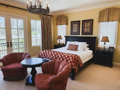 a bedroom with a bed and two chairs and a table at Villa Arden Hills in Sacramento